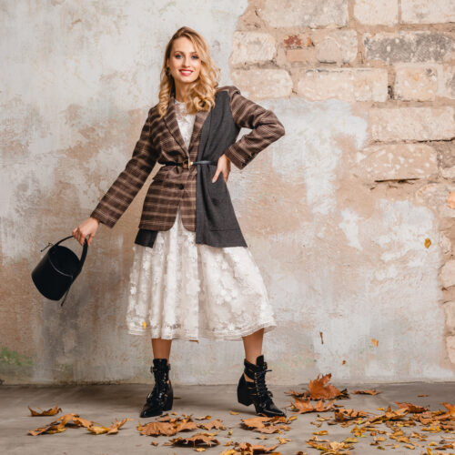 attractive stylish blonde woman in checkered jacket coat walking, autumn fashion trend